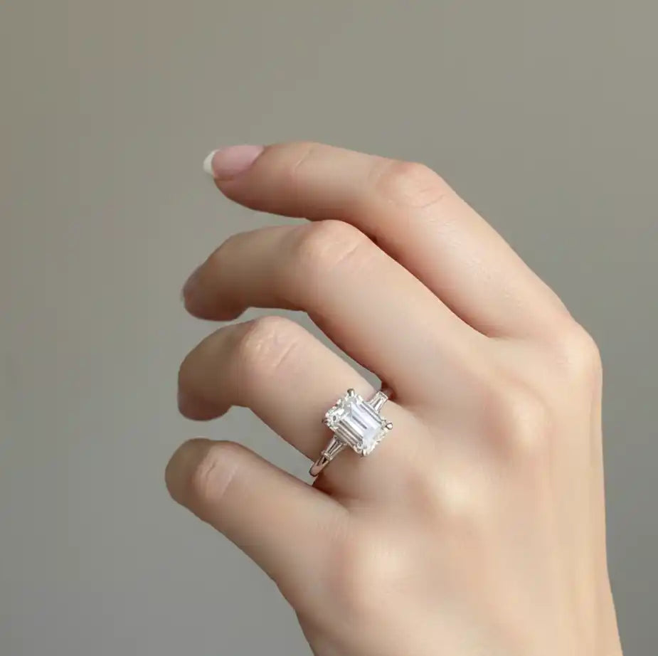 Emerald cut engagement ring on hand showing elongated diamond shape
