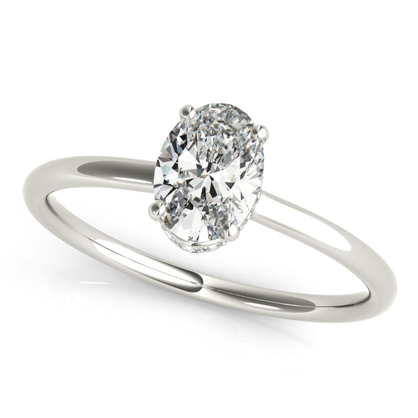 This elegant oval engagement ring features a sparkling hidden halo of diamonds that wraps around the center diamond.