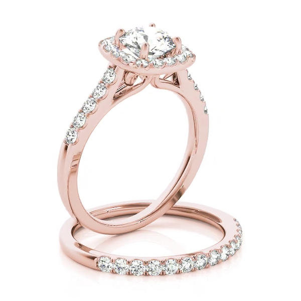 This delicate design engagement ring showcases a cushion halo pave set diamonds to frame a round cut diamond of your choice. Pink